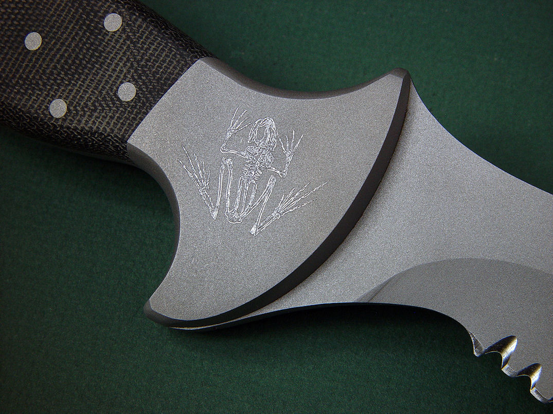 Bone Frog engraving on "Horus" bolster, reverse  side view in ATS-34 high molydenum stainless steel blade, 304 stainless steel bolsters, engraved, Micarta phenolic handle, locking kydex, aluminum, stainless steel sheath with black lacquered brass engraved flashplate.